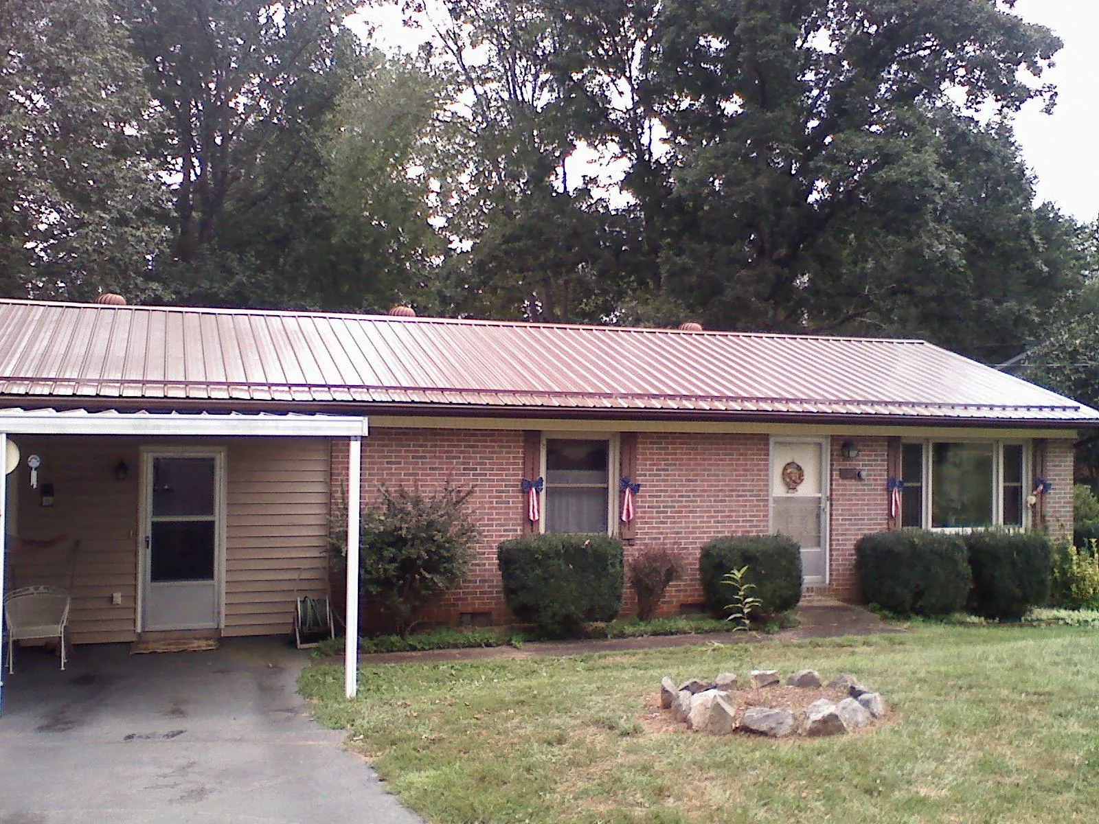 Bronze metal roof and carport on a brick ranch home — Roof Repair work by our crew in Bushnell
